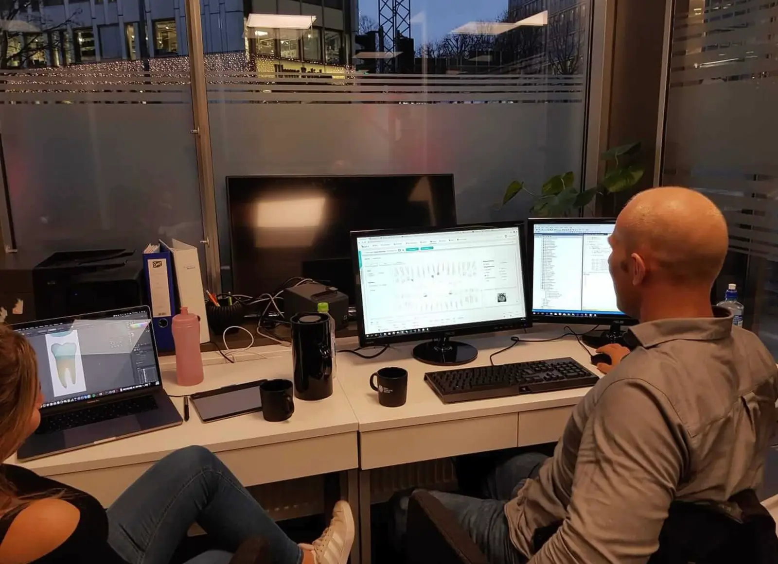 To utviklere hos Anita Systems i Oslo jobber med journalsystemet på flere skjermer