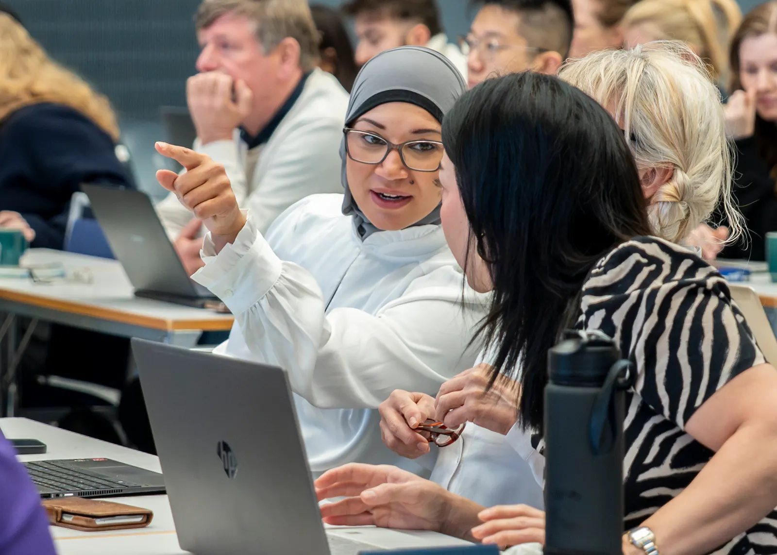 Kursdeltakere med laptoper i samtale under et Anita-kurs